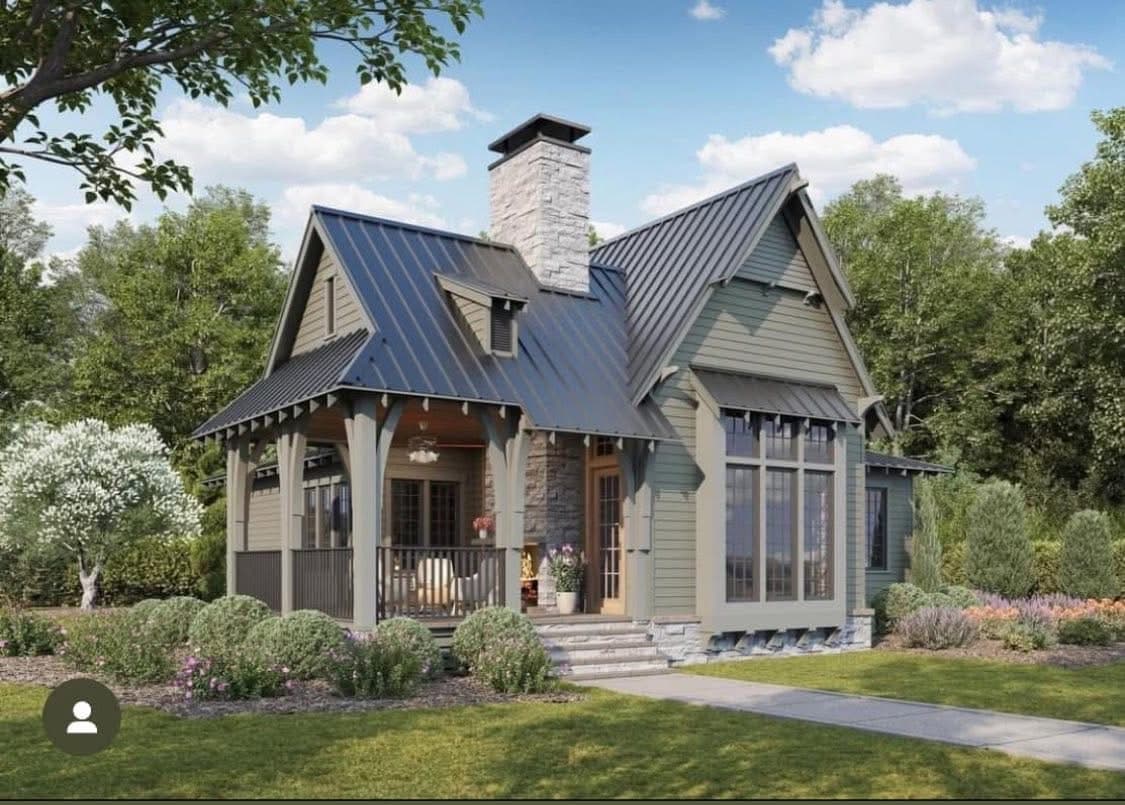 Sage green cottage with stone chimney and metal roof
