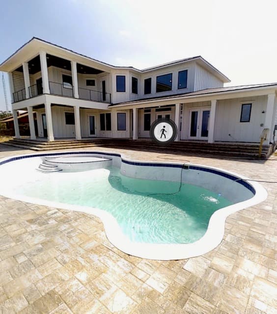 Backyard pool and spa with white custom home