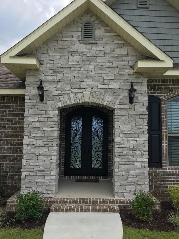 Stone arched entry with iron-detailed double doors